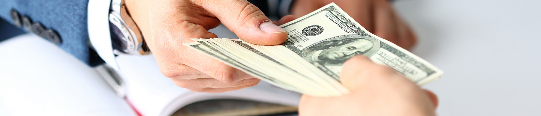 Dealership employee handing over cash for a trade