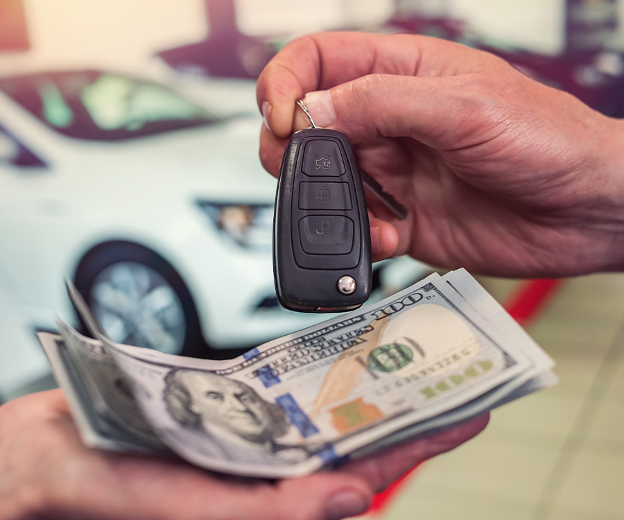 Dealership employee handing over cash for a trade