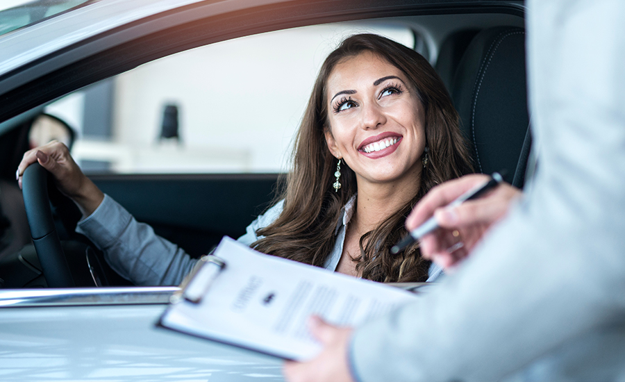 Car salesman with contract and the buyer.