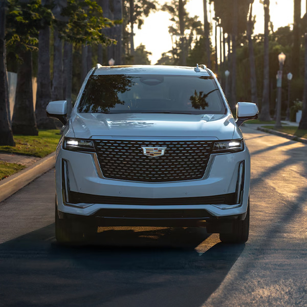 Head on shot of Cadillac SUV driving down road