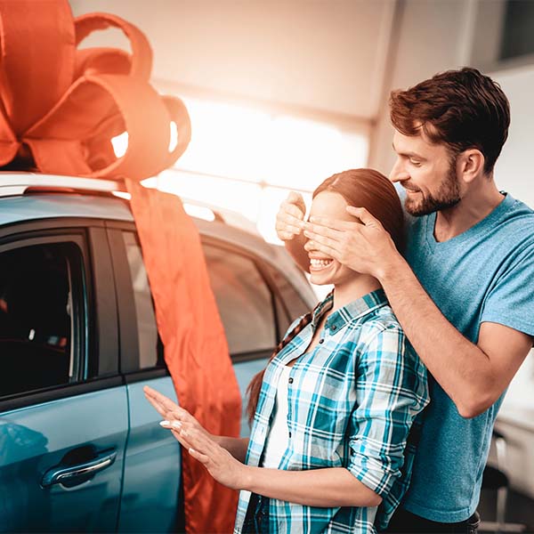 Man surprises woman with a new car gift.